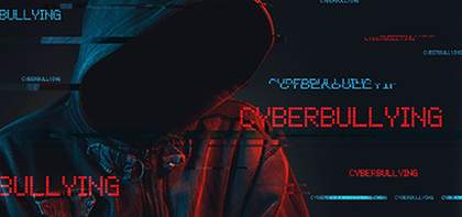 Youth in hoodie looking slightly down so face is dark and not distinguishable with cyberbullying words over the image